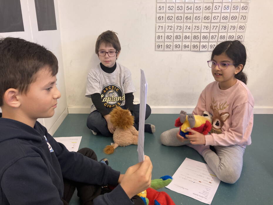 Ein Kind liest die Geschichte mit den übersetzten Begriffen und Sätzen vor. Die anderen Kinder setzen die Geschichte mit Plüschtieren szenisch um. Aufnahme Sadiye Bircher
